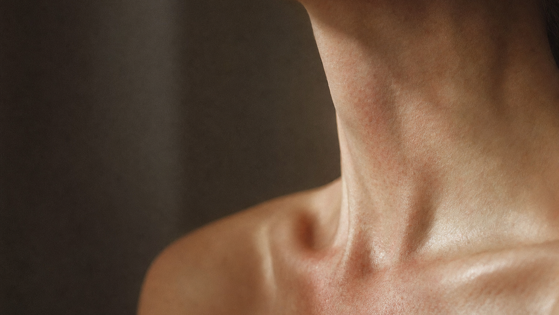 Close-up of a woman's neck and collarbone with faint patches of redness