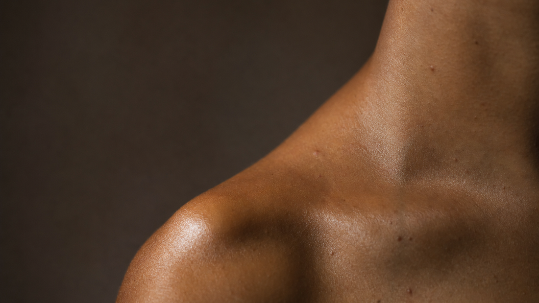 Close-up of a bare shoulder and upper back against a dark background