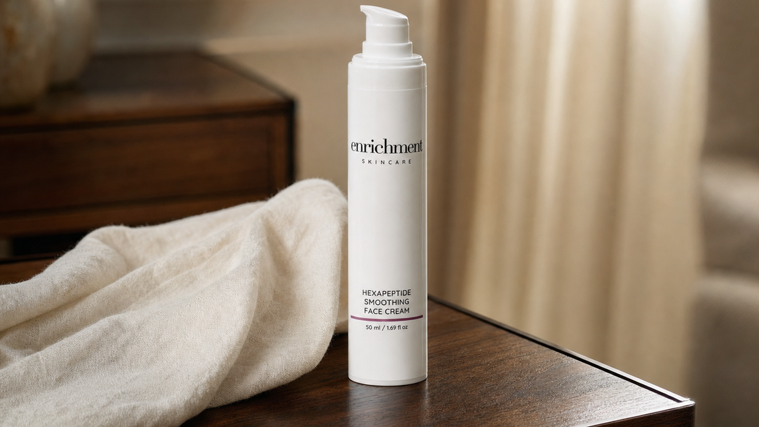 Enrichment Skincare Hexapeptide Smoothing Face Cream pump bottle on a wooden bedside table beside a soft folded throw