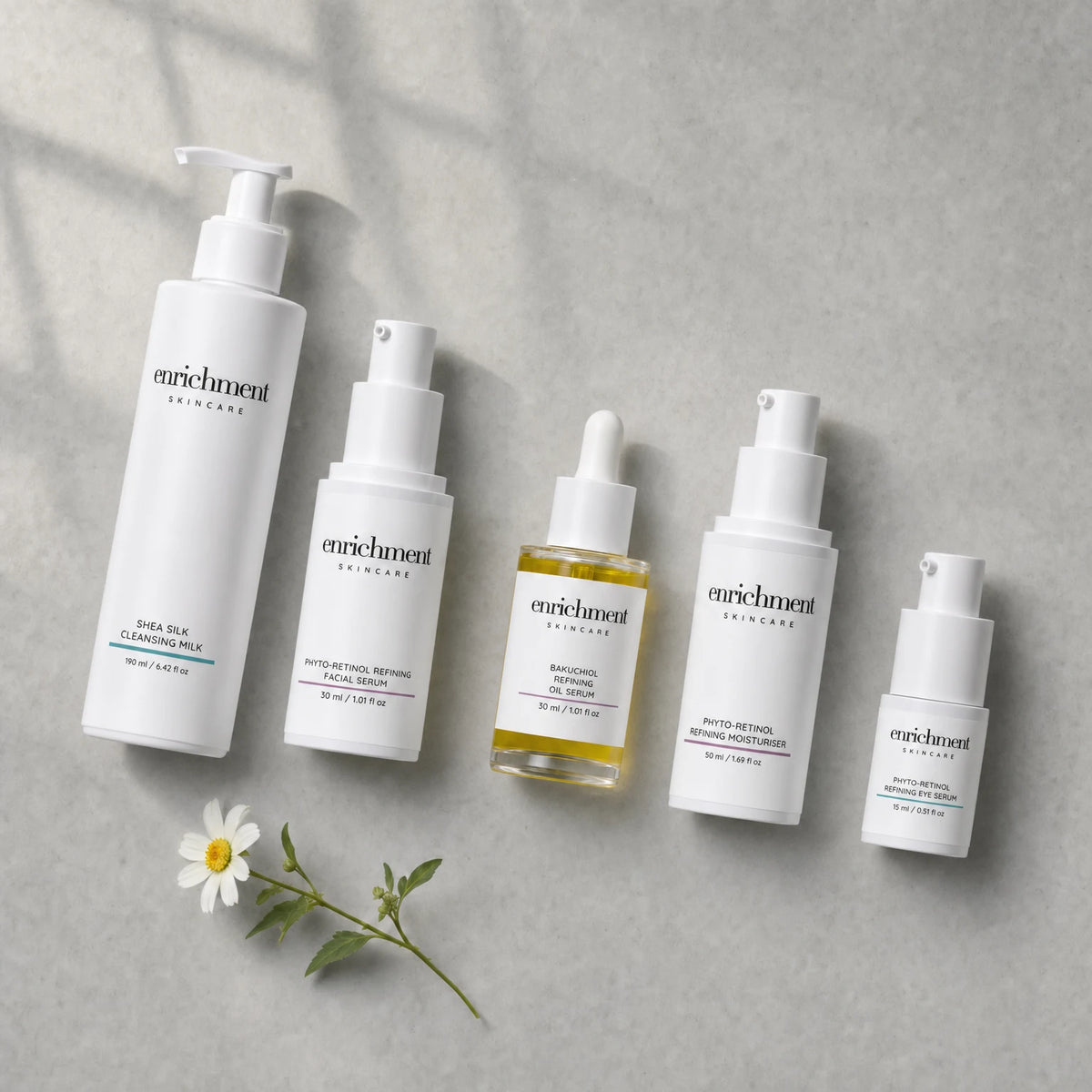 The five products in the set laid out from top left to bottom right in usage order, with a small white wildflower