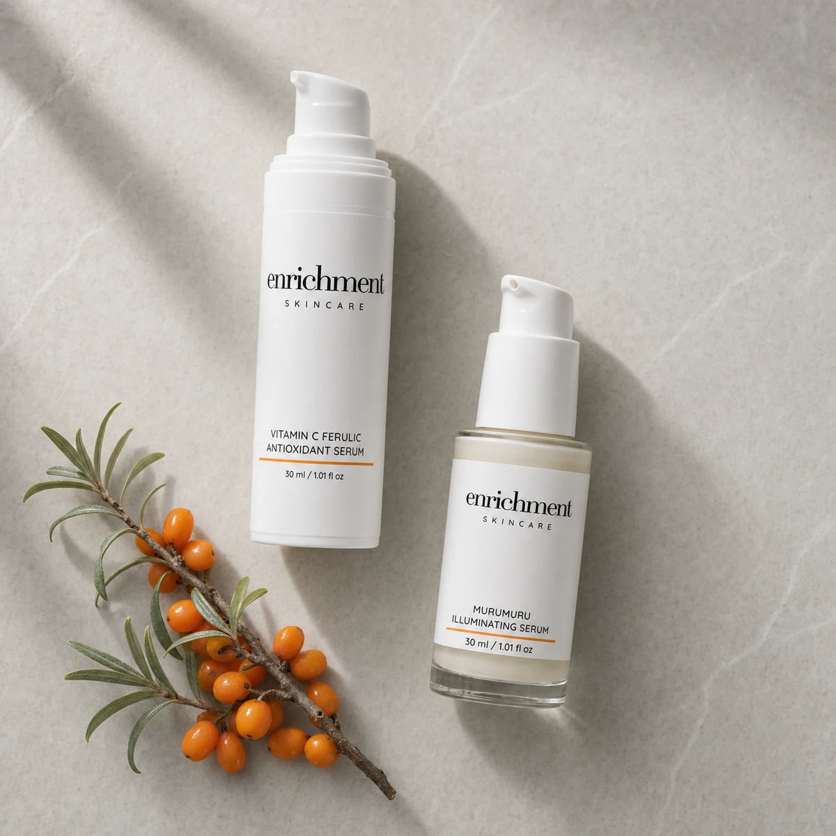 The two Duo serums laid out in morning usage order beside a sprig of sea buckthorn berries