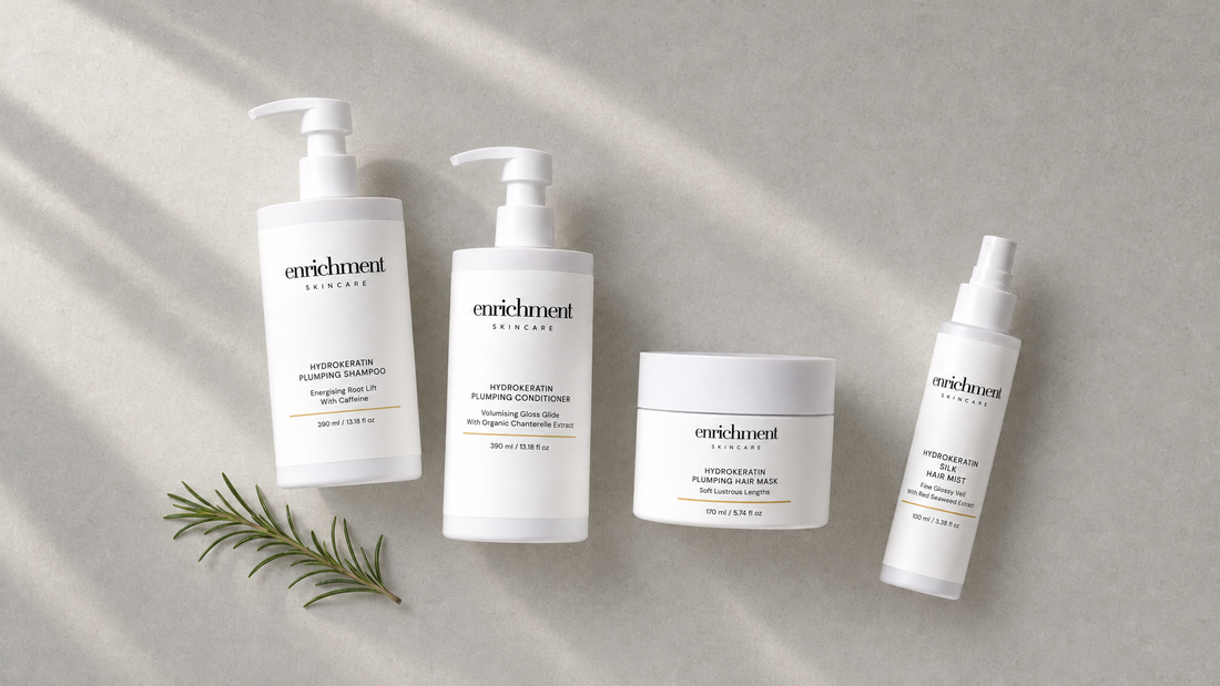 Hydrokeratin Plumping Shampoo, Conditioner, Hair Mask and Silk Hair Mist laid out on a pale stone surface with a sprig of rosemary
