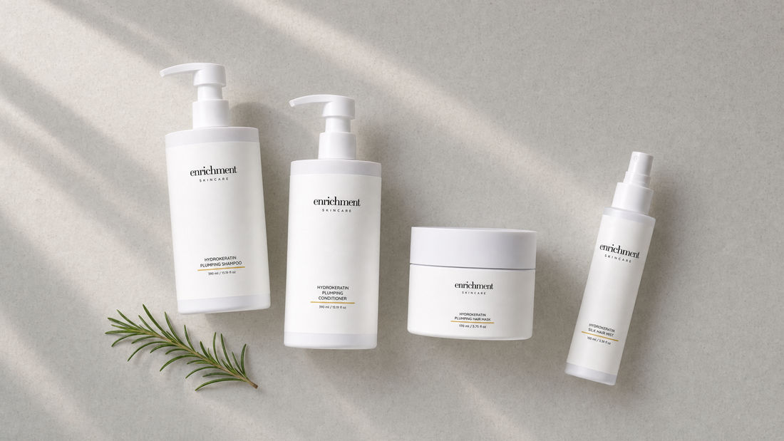 Hydrokeratin Plumping Shampoo, Conditioner, Hair Mask and Silk Hair Mist laid out on a pale stone surface with a sprig of rosemary