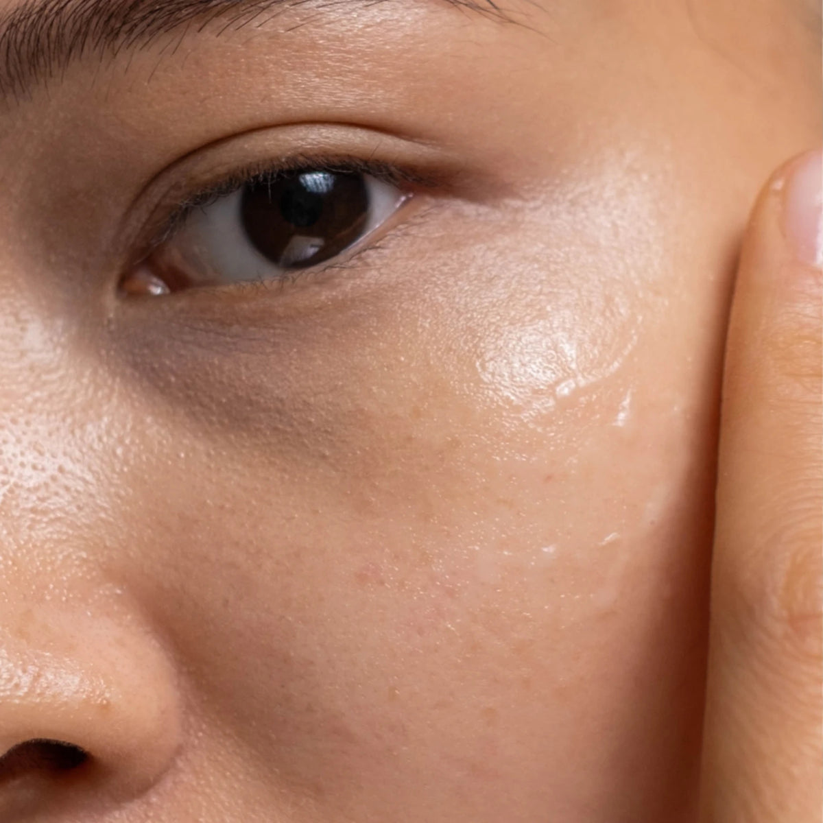 Close-up of a person applying Illuminating Niacinamide Gel to their cheek