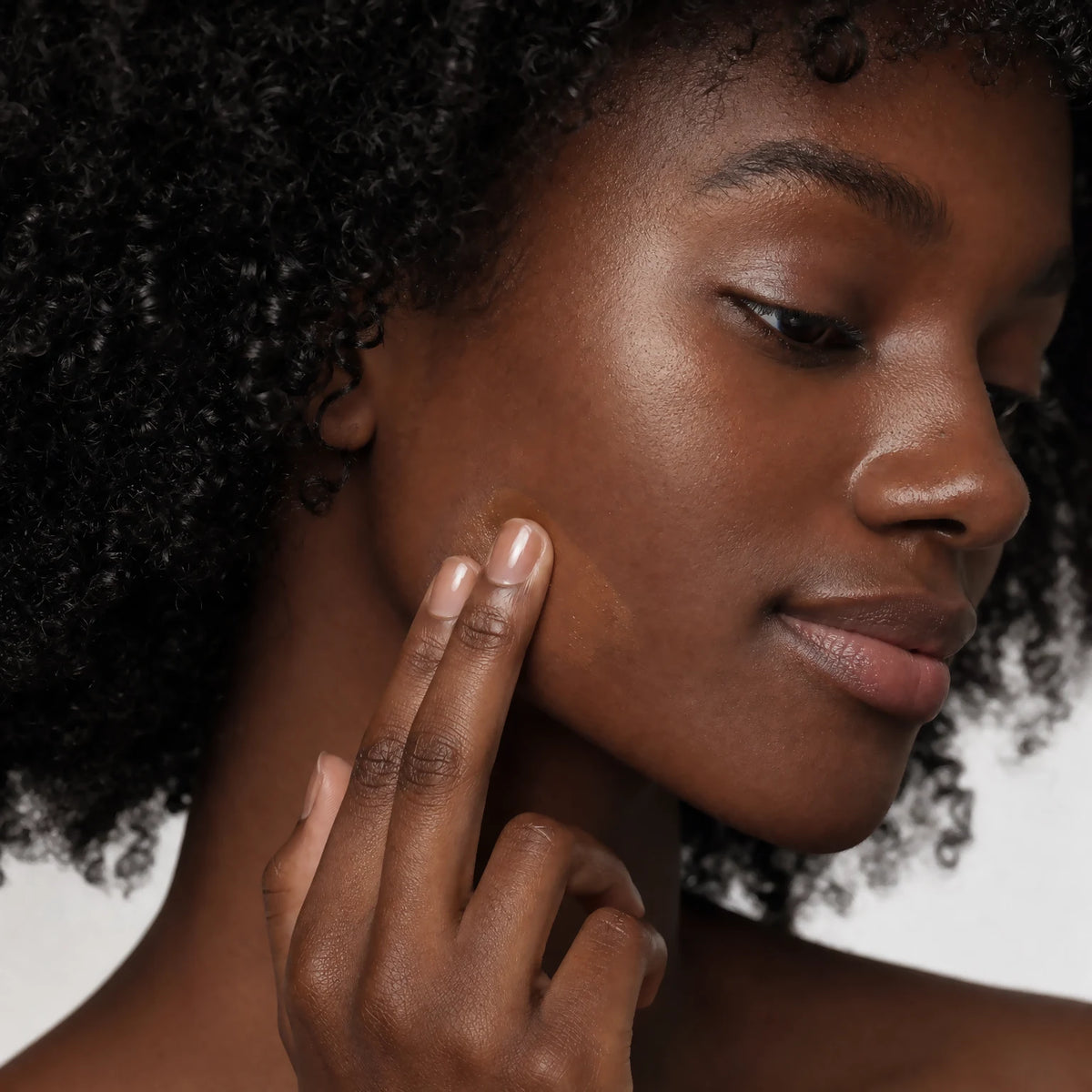 Two fingertips applying the Ceramide CC Stick SPF30 Deep tint into matching skin