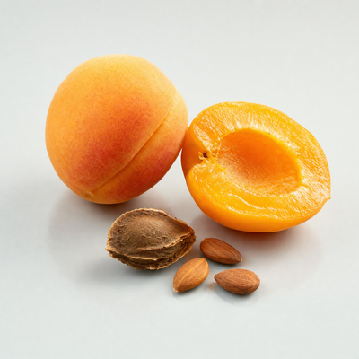 Fresh apricots, one halved, with apricot kernels and an opened stone
