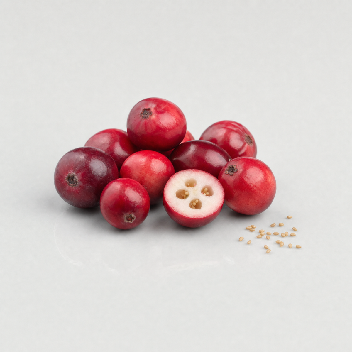 Fresh cranberries, one cut in half to show the tiny seeds