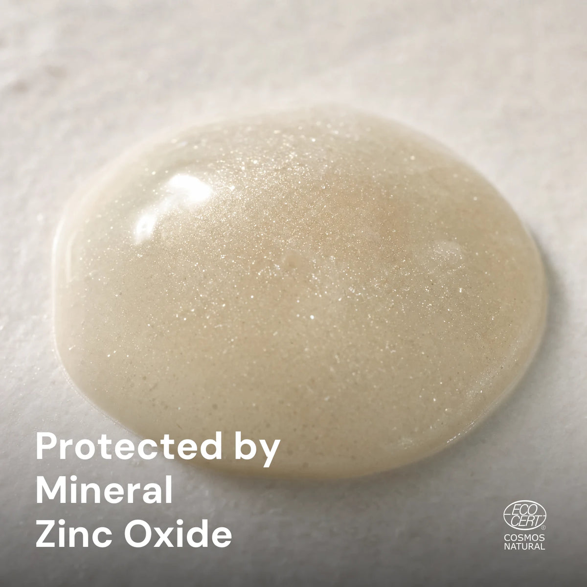 Zinc oxide pearlescent shimmer suspended in a glossy tinted fluid droplet