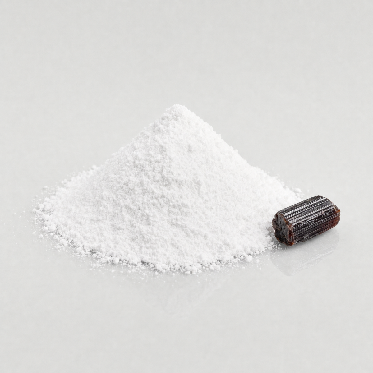 A heap of bright white titanium dioxide powder beside a raw rutile crystal