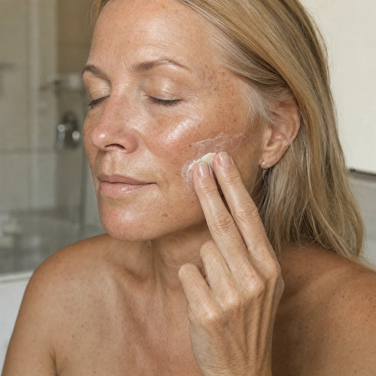 Applying Kojic Acid Illuminating Cream to the cheek
