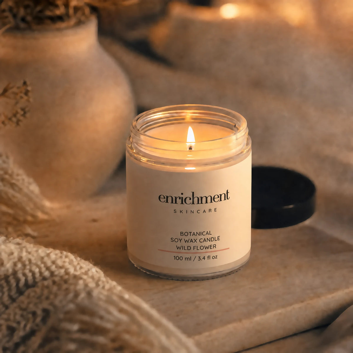 Enrichment Botanical Soy Wax Candle - Wild Flower lit candle in a warm ambient setting
