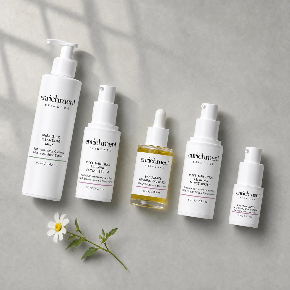 The five products in the set laid out from top left to bottom right in usage order, with a small white wildflower
