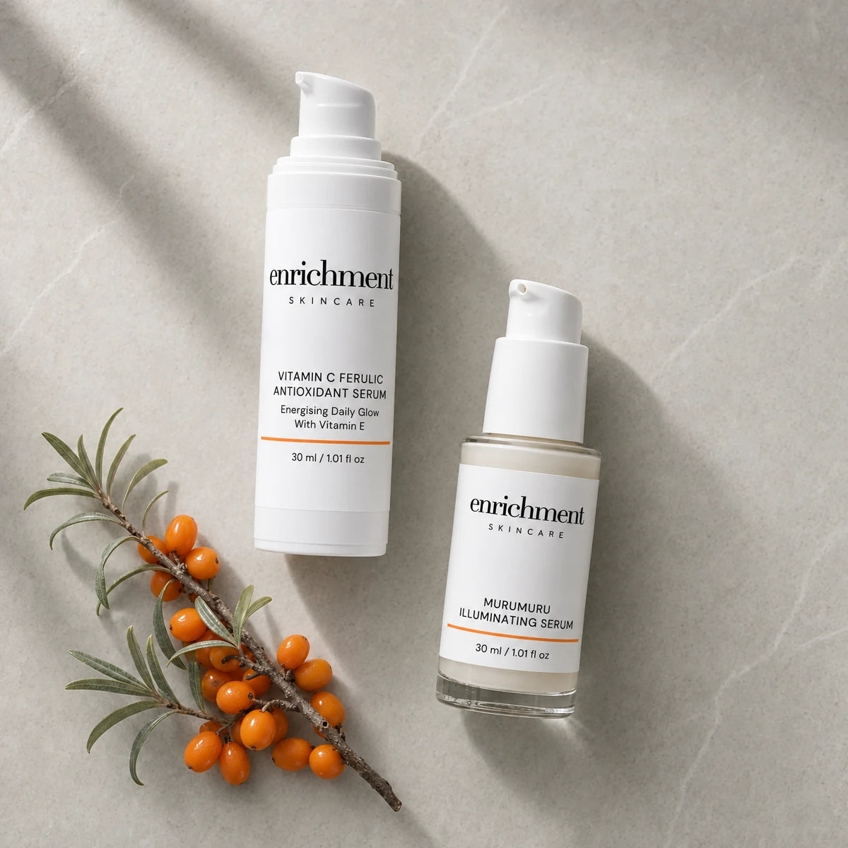 The two Duo serums laid out in morning usage order beside a sprig of sea buckthorn berries