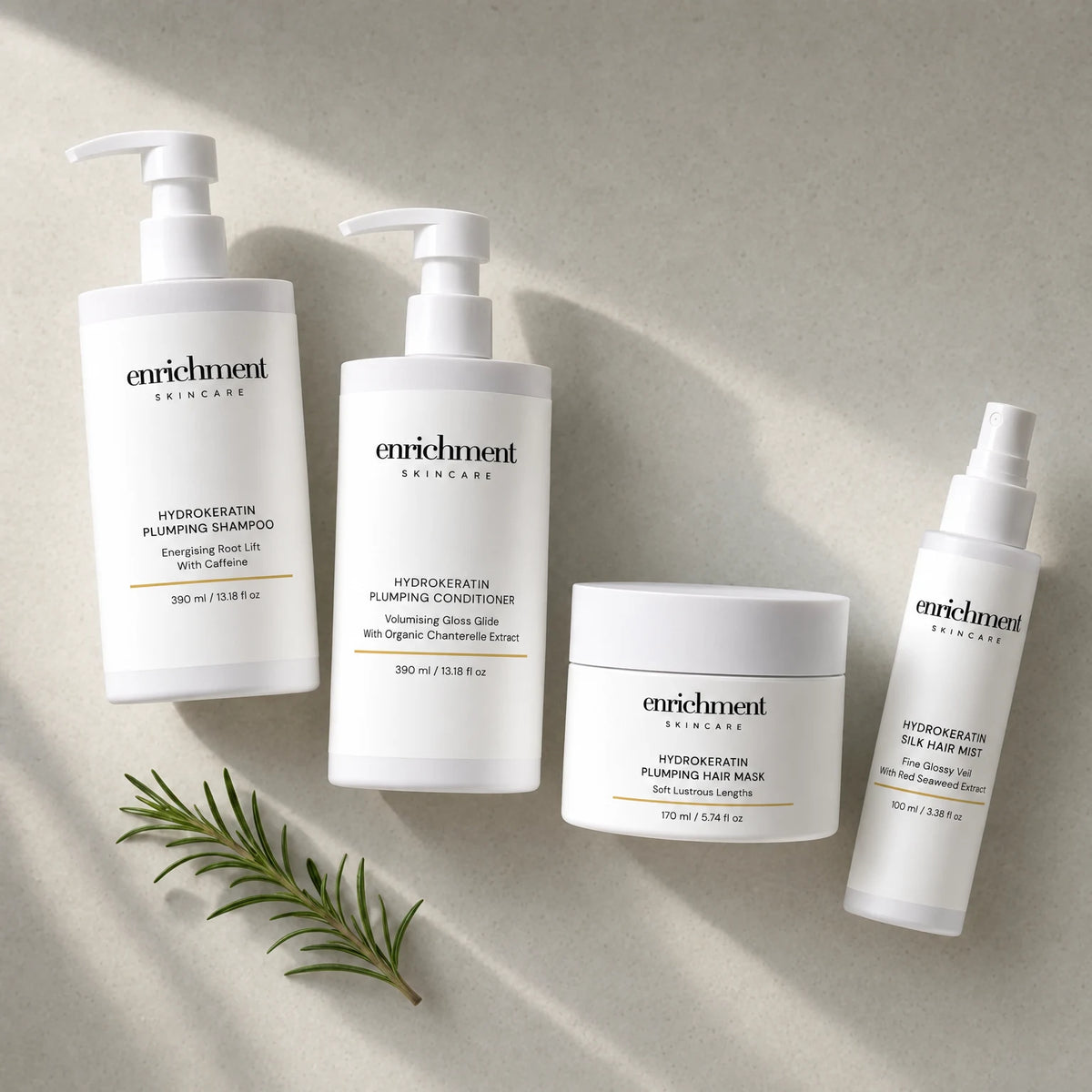 The four Hydrokeratin products laid out from top left to bottom right in usage order, with a small sprig of rosemary