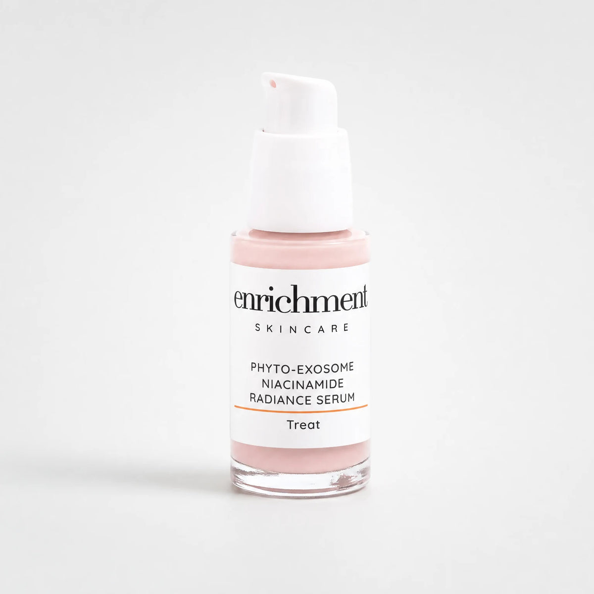 Enrichment Phyto-Exosome Radiance Serum in a clear glass bottle with a white pump, pale pink cream-serum visible through the glass, on a soft grey studio background