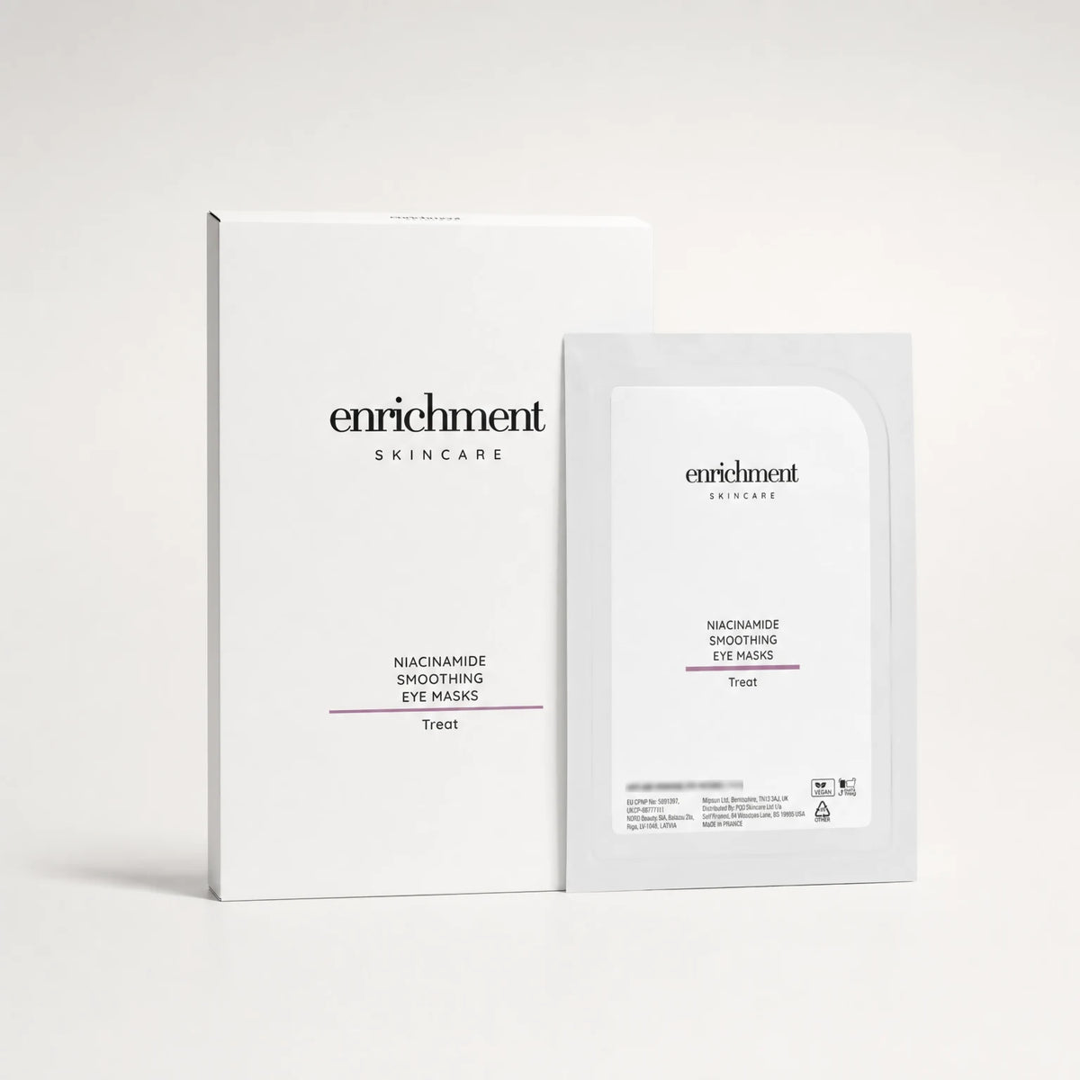 Enrichment Niacinamide Smoothing Eye Masks carton with one sachet on a soft grey studio background