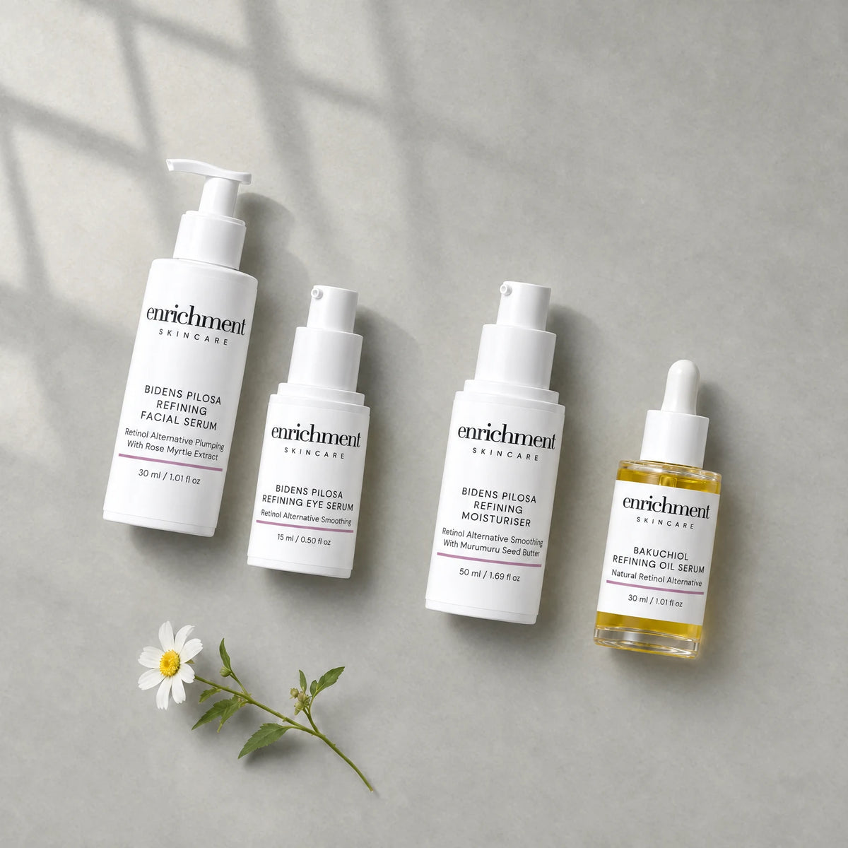 The four products in the set laid out from top left to bottom right in usage order, with a small white wildflower