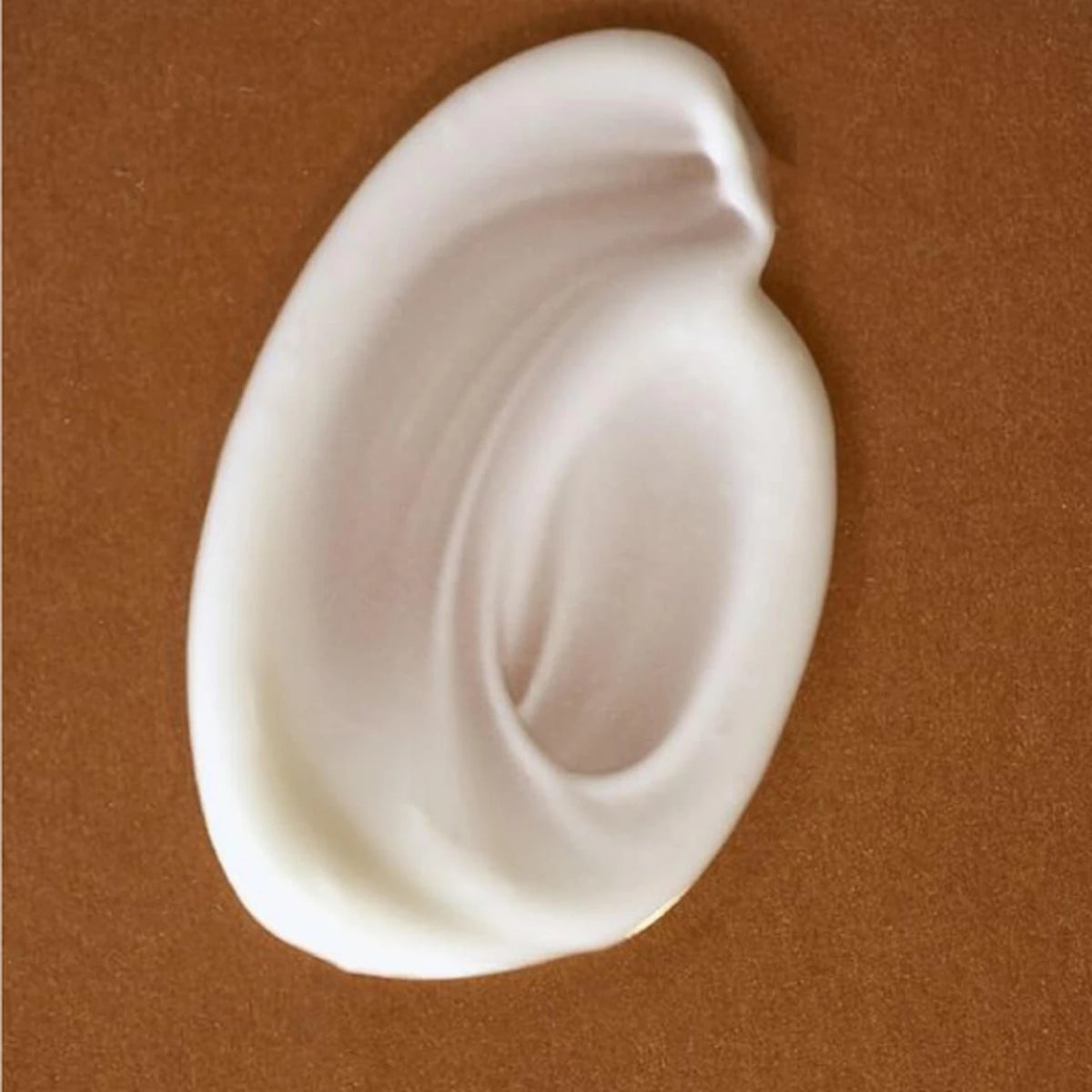 Swirl of Jojoba Endurance Day Cream on a brown surface