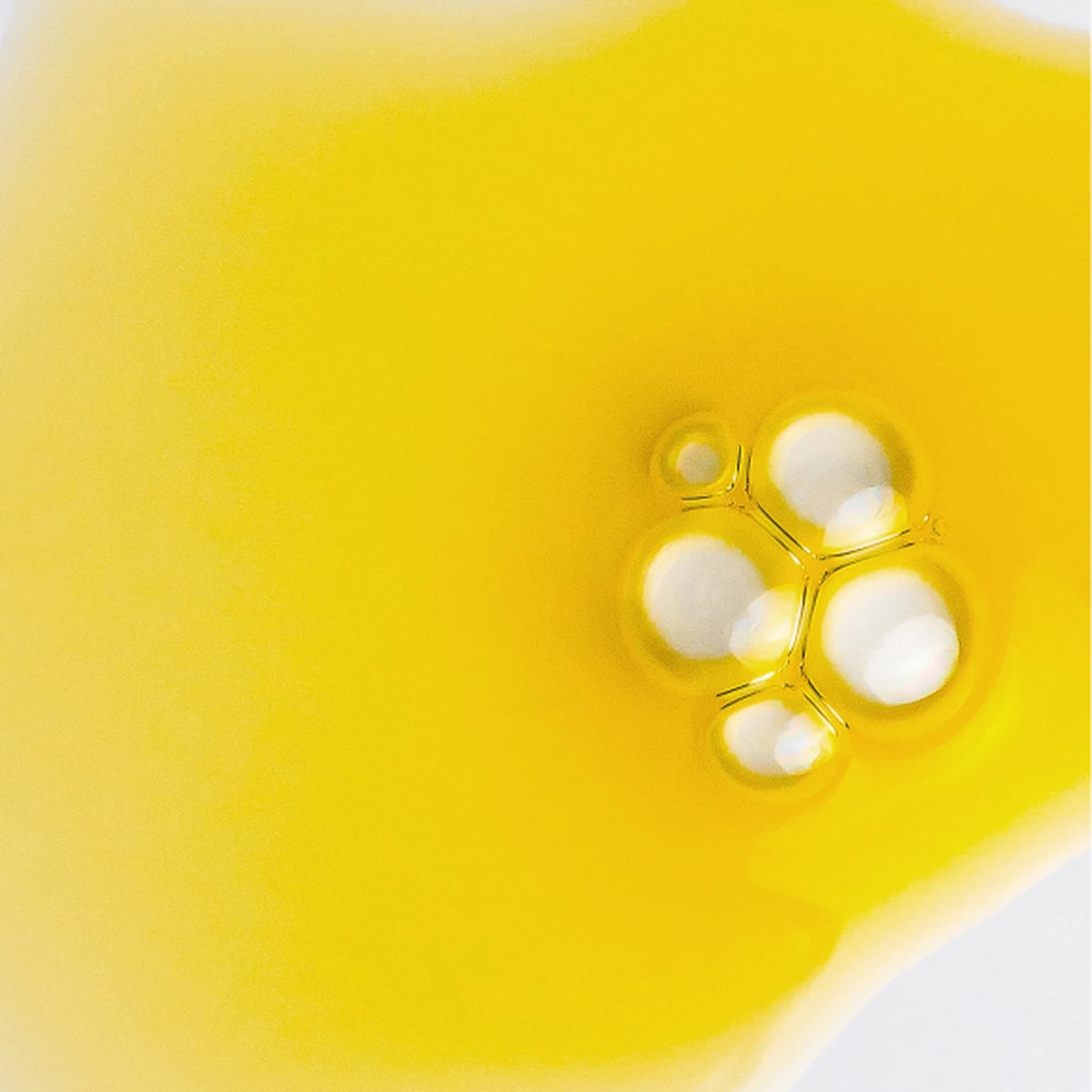 Enrichment Bakuchiol Refining Oil Serum golden dry-oil formula texture with bubbles, close-up macro shot